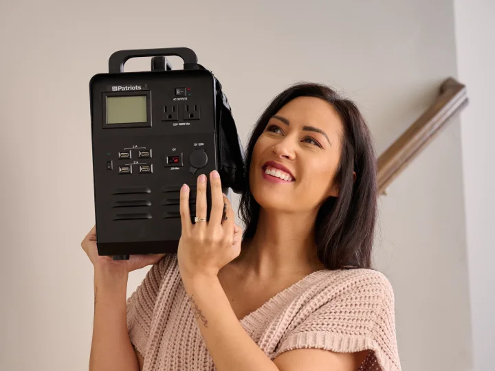 Current-model Patriot Power Generator 1800 held by a person to show its built-in carry handles