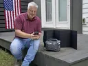Patriot Power Sidekick charging a phone beside the folding solar panel